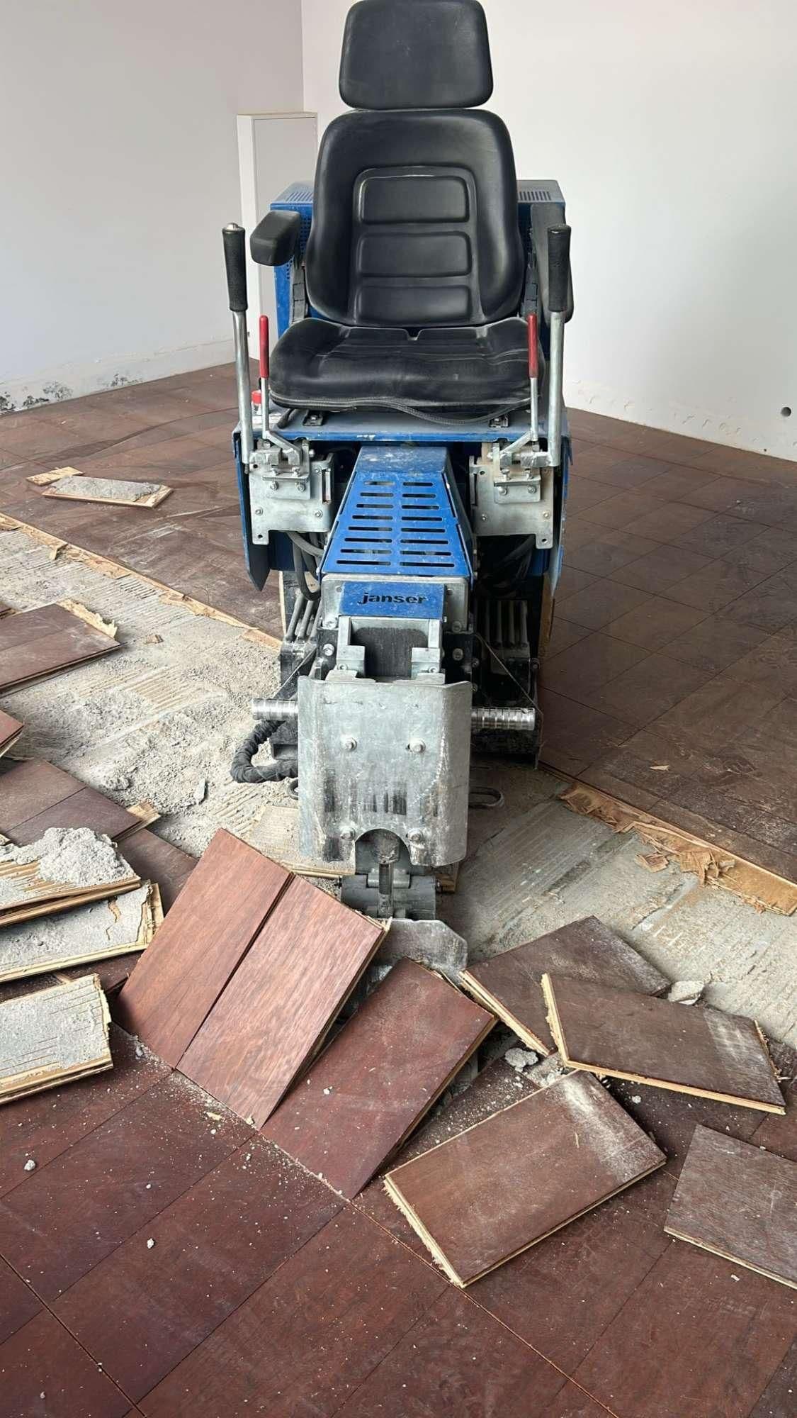 Zitmachine die houten vloerpanelen verwijdert in een binnenruimte